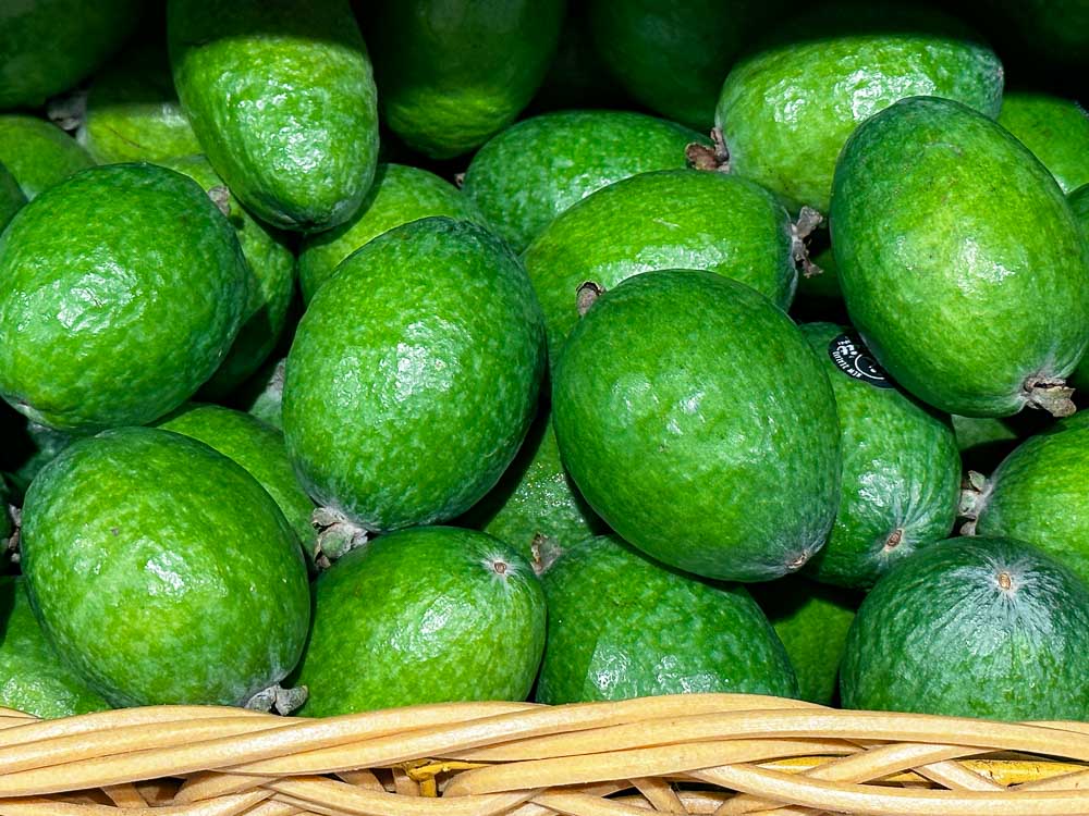 green round fruit called feijoa in a basket