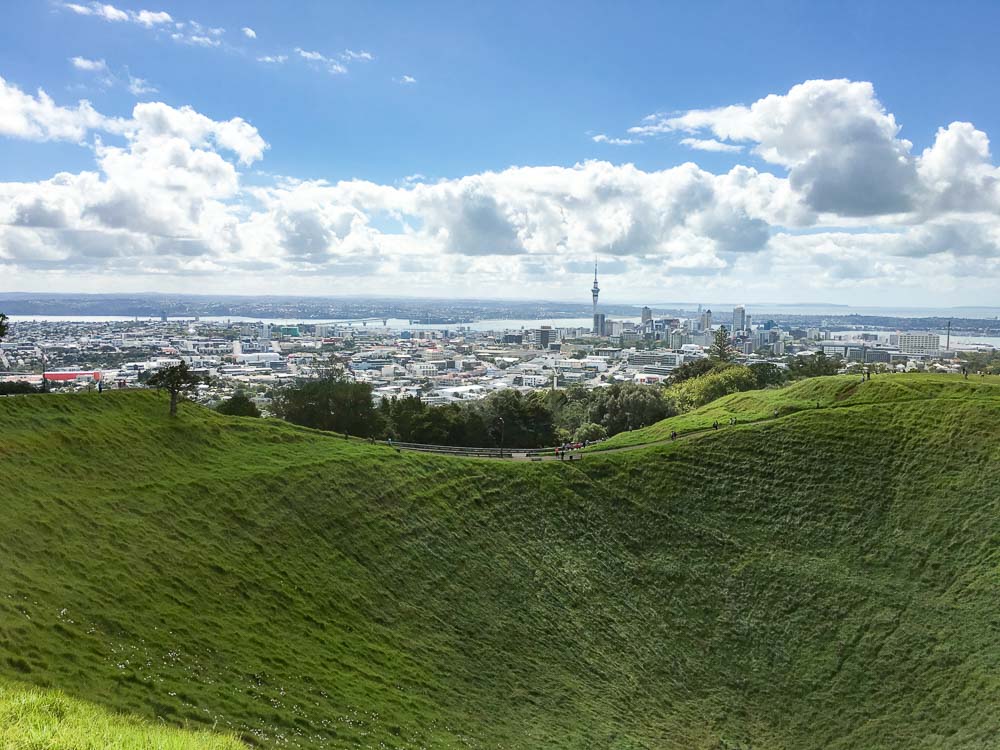 Views of Auckland City in the distance seen from a grass covered volcanic crater of Mt Eden, a suburb of Auckland.