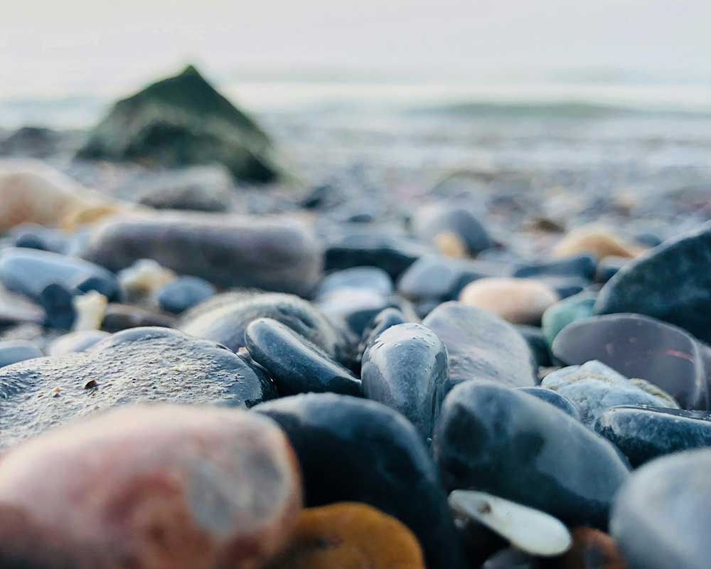Close up of colourful pebbles on a beach in Southland, New Zealand. 