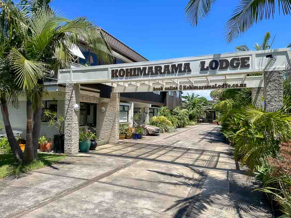 Exterior of the Kohimarama Lodge with tropical landscaping on a clear summer day.