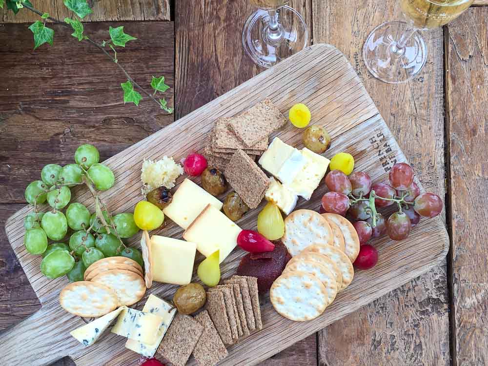 cheese and crackers on a wooden serving board