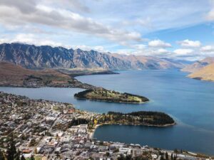 Aerial view of Queenstown New Zealand surrounded by a large blue lake and mountains