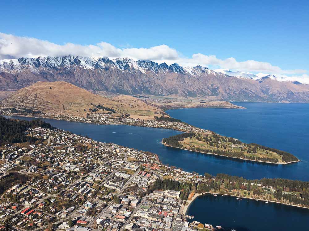 Aerial view of Queenstown New Zealand surrounded by a large blue lake and mountains