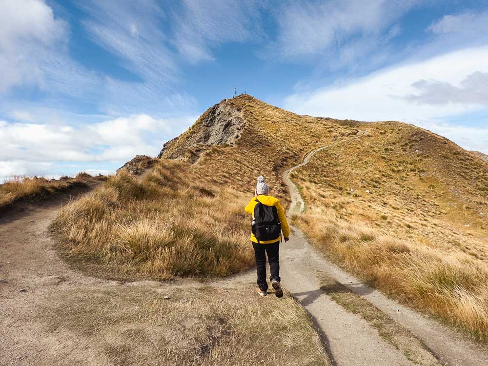 girl standing front of a fork in a path on a mountain