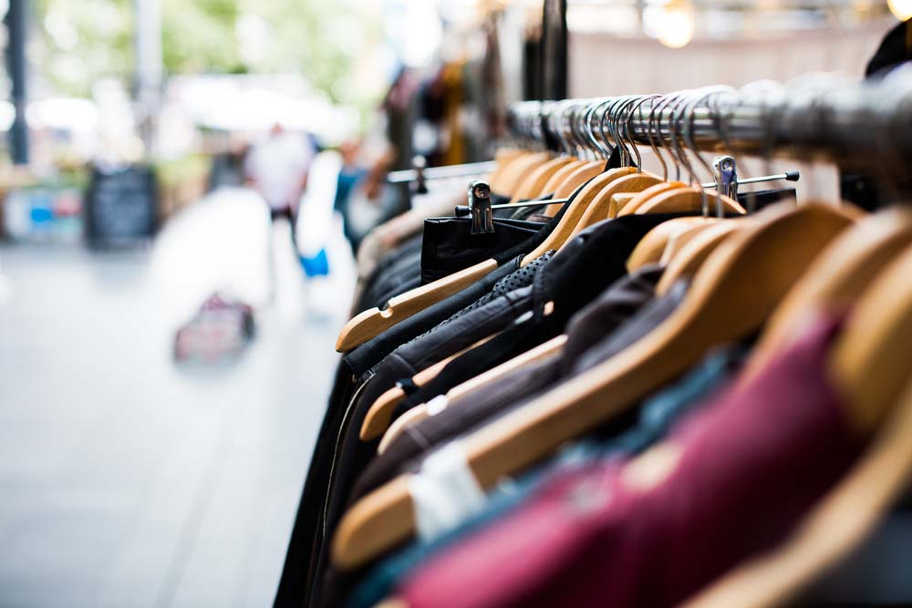 Close up of hangers on a clothing rack outside of a shop.