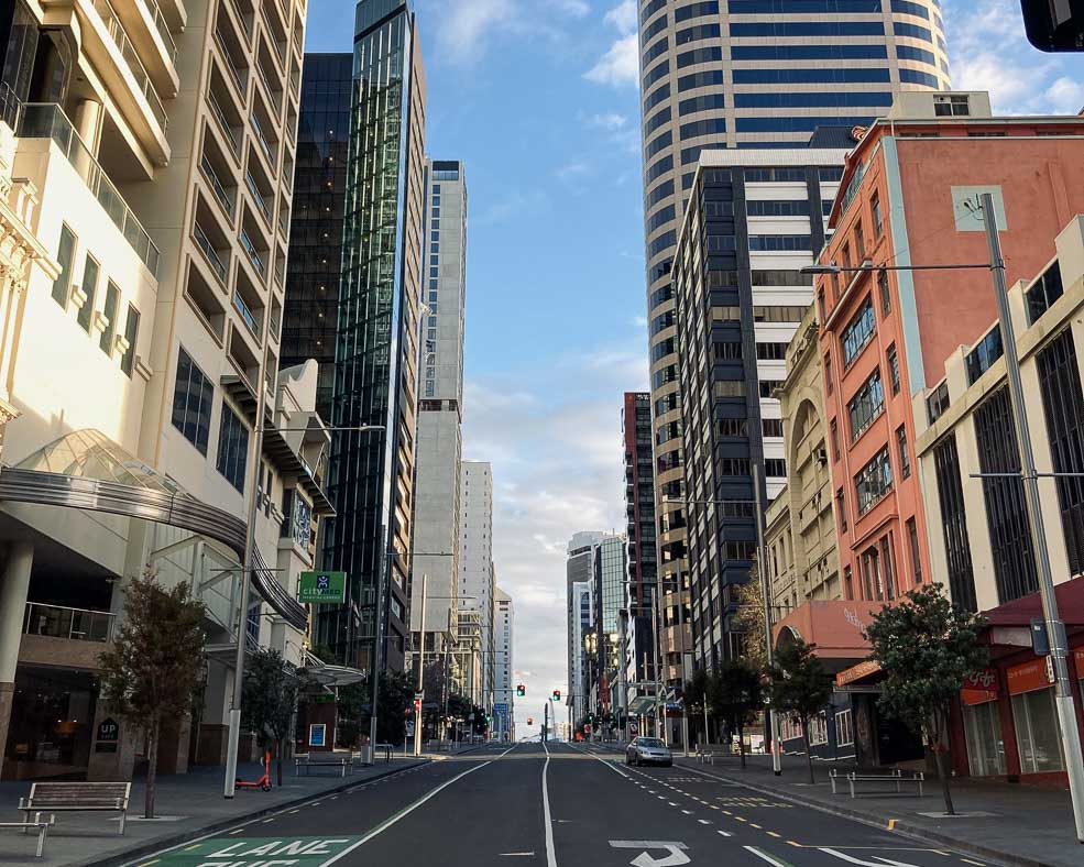Looking up a street in Auckland CBD with tall buildings along each side of the road.