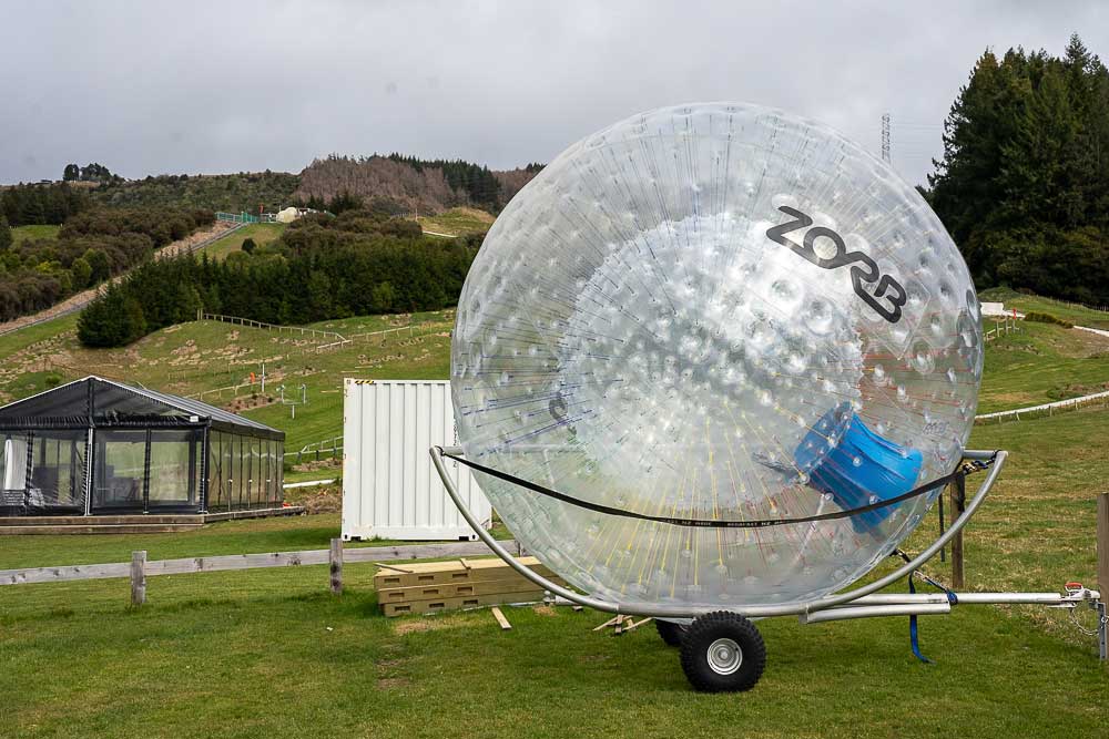 Close-up of a ZORB inflatable ball with the large green hills used for zorbing at ZORB Rotorua in the background.